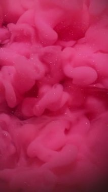 Dikey video. Bulut boyası. Buhar dokusu. Soyut siyah akrilik zemin üzerinde yüzen sönük pembe renkli simler..