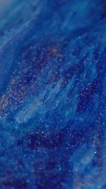 Dikey video. Parıltılı boya karışımı. Köpüklü mermer. Odaklanmamış mavi turuncu renk parçacıkları doku karışımı soyut sanat arkaplanı akışı.