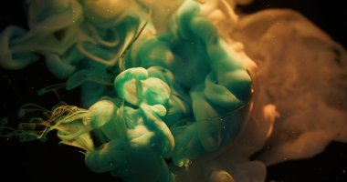 Boya sisi. Bulut karışımı. Odaklanmamış mavi renkli gökkuşağı parıltısı kırılan camlar soyut koyu siyah sualtı arka planına sıçrıyor.