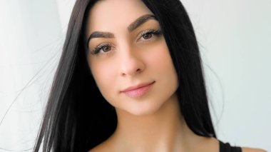 Güzel kadın yüzü. Kendine güvenen bir model. Uzun, sağlıklı makyajlı güzel bir kız. Beyaz arka planda izole edilmiş çekici bir kadın..