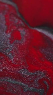 Dikey video. Parıltılı boya karışımı. Köpüklü mermer. Odaklanmamış kırmızı gri renk parçacıkları desen karışımı soyut sanat arkaplanı.