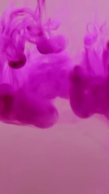 Dikey video. Su altı dumanı. Yüzen boya. Mor akrilik boya damlası rengi sis sıvısı çözünen pigmentler. Sanat kimyasal sıçrama soyut bulanık arkaplan.