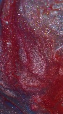 Dikey video. Canlı bir sıçrama. Parlak dalga. Soyut akrilik arkaplan üzerine yayılan odaksız kırmızı gümüş rengi ışıl ışıl parlayan doku.