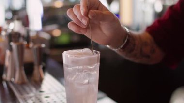 İçki servisi. Dondurmalı soda. Barmen el, bardaktaki soğuk suya çiçek açan lavanta filizi ekliyor. Çırpılmış beyaz kapaklı ferahlatıcı kokteyl..