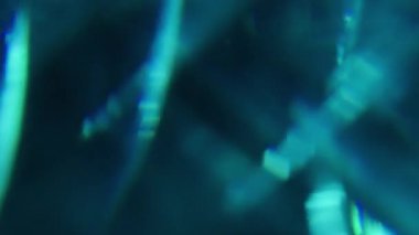 Bulanık mavi arka plan. Parlak ışık. Soğuk renk, parlak gölgeyi aydınlatır. Görsel olarak aydınlatılmış parlak sanat soyutlamasına yansıtır..