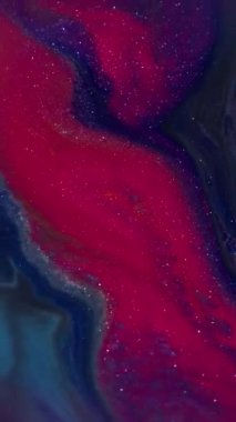 Dikey video. Parlak bulanık boya. Parlak mürekkep. Odaklanmamış kırmızı, kırmızı, renkli su, parlak doku sıvısı soyut sanat arka planında akıyor..