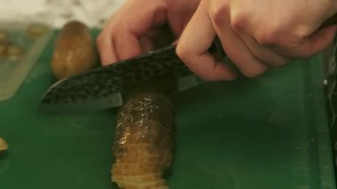 Aşçılık işi. Turşu dilimliyorum. Şef el, yeşil mutfak tahtasında tuzlanmış salatalık kesiyor. Vejetaryen yemeği için profesyonel hazırlık malzemesi..