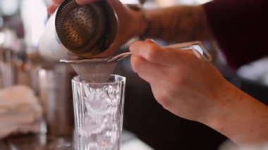 Karıştırılmış kokteyl karışımı. Barmen soyu. İşçi el, beyaz krem şanti sıvısını metal karıştırıcıdan cama döküyor. Profesyonel bar aracı.