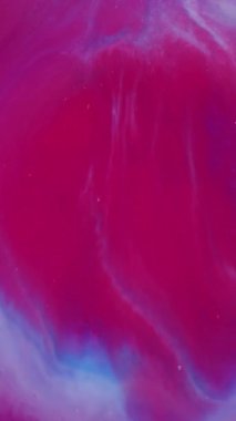 Dikey video. Parlak boya. Bulanık parlak sanat. Soyut akrilik arkaplan üzerinde sihirli su akışı sağlayan, pembemsi mavi renkli parlak dokular..