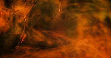 Su altı dumanı. Mürekkep dumanı. Siyah arka planda turuncu kırmızı boya dökülmüş. Soyut bulut parlaklık dalgası karışımı Gece sıvısında renk sıçraması.