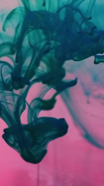 Dikey video. Sıvı mürekkep damlası. Su damlacıklarını boya. Renk damlatma karışım akışı odaklanmış pembe sıvı. Turkuaz sanat dumanı girdap karışımı arkaplan dokusu.
