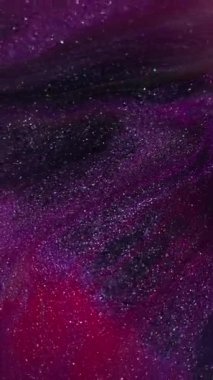 Dikey video. Mermer boya. Bulanık renk karışımı. Soyut sanat üzerine odaklanmış pembe parıltı dokusu su sıvısı koyu siyah zemin.