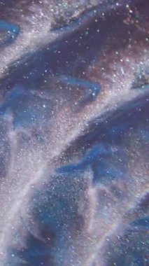 Dikey video. Köpüklü boya. Akış parçacıkları. Soyut ışık arkaplanı üzerinde yüzen odaksız mavi mor renk dalgası sim sıvısı.