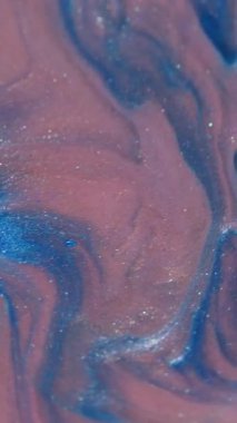Dikey video. Damla sıçraması. Boya akışı. Odaklanmamış mavi bronz mor renkli parlak doku soyut akrilik arka planda yüzüyor..