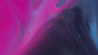 Parıldayan mürekkep. Renk sıvısı akıyor. Odaklanmamış pembe mavi su dokusu soyut sanat arka planında yüzen koyu siyah lekeler..