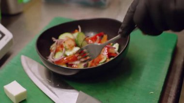 Salata hazırlıyorum. Besin tabağı. Şef el, taze kesilmiş sebze peyniriyle geleneksel yemekler yapıyor. Kafeterya mutfağında sağlıklı vejetaryen yemeği.