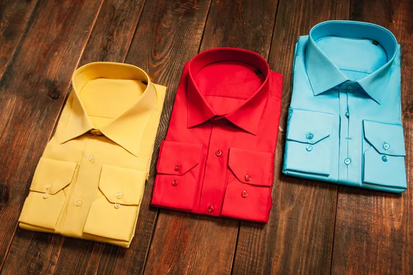 Colorful men's shirts on a wooden background — Stock Photo, Image