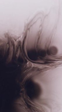 Dikey video. Sıvı doku. Bulanık mürekkep sıçraması. Odaklanamayan siyah su lekesi soyut beyaz sanat arka planında yüzen sıvı pigmenti.