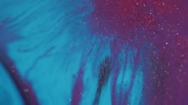 Boyayı yayıyorum. Akrilik doku. Soyut bokeh arkaplanda yüzen mor pembe parlak sıvı pigment..