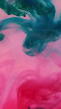 Dikey video. Mürekkep dökme suyu. Pigment karışımı. Sis rengi sıvı mistik karışımı sıçratır. Sanat akışı şeffaf pembe turkuaz soyut odaklanmış arkaplan.