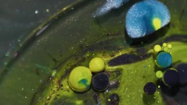 Parıltı emülsiyonu. Yağlı boya topu. Soyut sanat arka planında yüzen köpüklerin etrafında sönük sarı mavi renk parıltı dokusu.