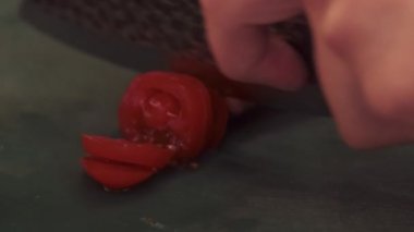 Yemek pişirme süreci. Sebze dilimliyorum. Eller taze doğal malzemeleri kesiyor. Şef kasede salatalık ve vejetaryen salatası tartıyor..