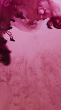 Dikey video. Sıvı mürekkep damlası. Su damlacıklarını boya. Mor damlayan karışım buhar akışı bulanık pembe sıvı. Renk sanatı sıçraması duman karışımı arkaplan dokusu.