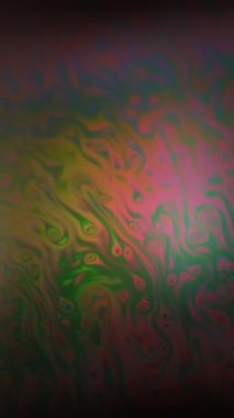 Dikey video. Bulanık parlama. Renkli yağ. Siyah dokuda kırmızı yeşil mürekkep yakıtı karışımı. Gradyan girdap suyu soyut arkaplan.