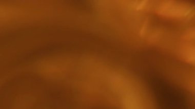 Odaklanamayan parıltı. Bokeh kıvrımlı dokusu. Turuncu renkli, parlak, yuvarlak sanat parıltısı soyut, aydınlık, siyah arka planda parlıyor..