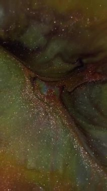 Dikey video. Bulanık dalgalı boya. Işıldayan arka plan. Odaklanmamış turuncu yeşil renkli sim desen su gökkuşağı sanat soyutlaması.