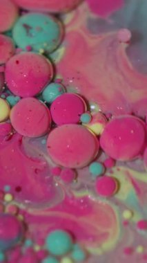 Dikey video. Yağ damlası. Sıvı arka plan. Sanatın soyutlamasına akan mermer su yuvarlak desenli bulanık mavi sarı mürekkep..