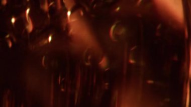 Bulanık turuncu ışık. Parlak bir doku. Altın renkli parlak folyo parıltısı soyut ışıltı arkaplanda ışıldıyor..