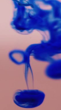 Dikey video. Sıvı mürekkep damlası. Su damlacıklarını boya. Mavi damlayan karışım çözünmüş şeftali suyu. Renk sanatı kimyasal reaksiyon dumanı arkaplan dokusunu karıştırır.