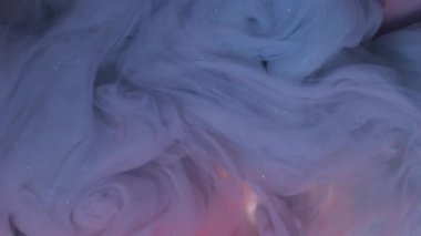 Kıvrımlı ışıldayan boya. Buhar sanatı. Soyut arkaplanda bulanık mavi pembe mürekkep simli akrilik kimyasal ışıl ışıl madde.