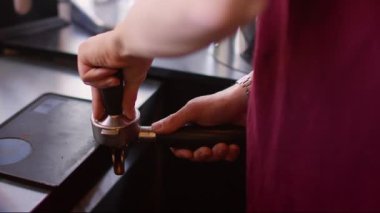 Espresso hazırlanıyor. Kahve dolduruyorum. Barista 'nın eli metal kornada taze öğütülmüş fasulye tozu. Profesyonel restoran aletleri..