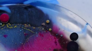 Jel boya. Mürekkep karışımı. Odaklanamayan mavi kırmızı renk su kabarcıkları etrafında yağ lekesi soyut arka planda siyah emülsiyon sızıntısı oluşturur..