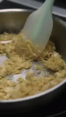 Dikey video. Haşlanmış pirinç. Asya yemeği pişirmek. Şef sıcak metal kızartma tavasına yağ ekliyor spatula ile yemeği karıştırıyor. Geleneksel doğu mutfağı.