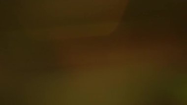 Odaklanamayan ışın lensi. Yansıma flaş dokusu. Turuncu yeşil parlak harmanlayıcı renk soyut koyu arkaplan. Optik sanat efekti.