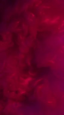 Dikey video. Köpüklü boya. Parıltı karışımı. Pembe mor menekşe boya karışımı fırtına dalgası. Renkli su arka planında ışıldayan floresan sızıntısı.