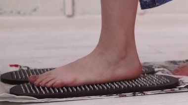 Sadhu masajı. Yoga tahtası. Dayanıklılık geliştiren bir kadın, manevi gelişen ruhsal sağlığın keskin tırnakları üzerinde çıplak ayakla duruyor..