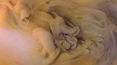 Boya karışımı. Su altı sarı sıvısı. Odaklanamayan pembe renkli akrilik bulut dokusu soyut ve canlı arkaplana sıcak su sıçratıyor..