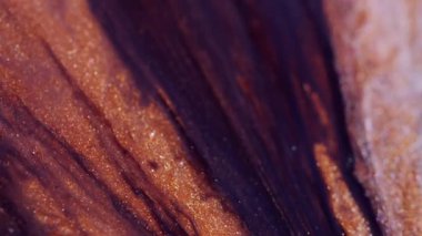 Odaklanamayan ışıldayan sızıntı. Damlalar boya. Turuncu kahverengi lavın üzerinde siyah, parlak bir sıvı akıyor. Soyut arkaplan üzerindeki damlacık akışı.