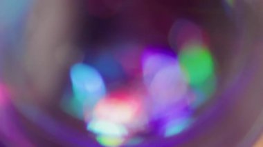 Kaleydoskop gecesinin dikkati dağıldı. Dairesel ışıltı. Gökkuşağı renkleri parlak kürede parıldıyor. Neon lens soyut mor kırmızı yeşil bulanık arkaplan.