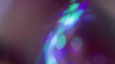 Odaklanamayan holografik ışıltı. Kaçak aydınlatma. Neon renkli küre siyaha yansıyan kaleydoskop dönüşü. Mor mavi soyut bulanık arkaplan.