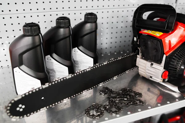 Sierra de cadena, exhibición de la botella de aceite en la tienda de herramientas —  Fotos de Stock