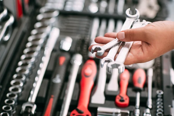 Trabajador en la tienda elige herramientas de llave inglesa — Foto de Stock