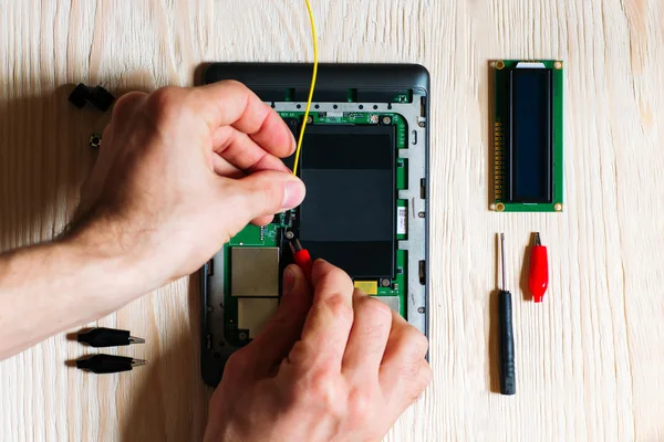 Técnico de reparación tableta de ordenador sobre fondo de madera — Foto de Stock