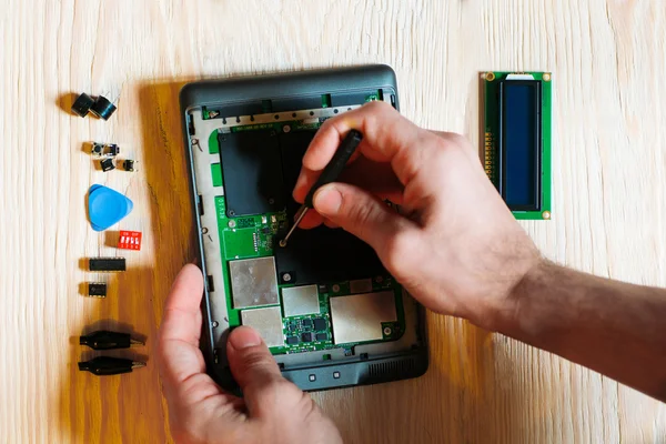 Technician repair tablet computer on wooden background — Φωτογραφία Αρχείου