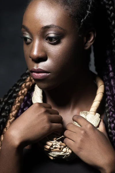 Задумчивая черная женщина с дизайнерским ожерельем — стоковое фото