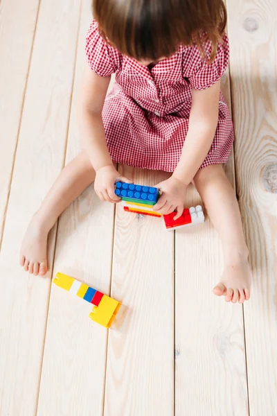 Dziewczynka na drewnianej podłodze gry Lego — Zdjęcie stockowe